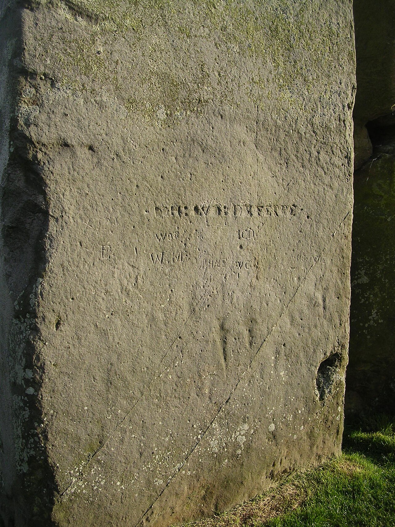 Stonehenge sarsen stone with faint ancient axe and dagger carvings visible on the surface.